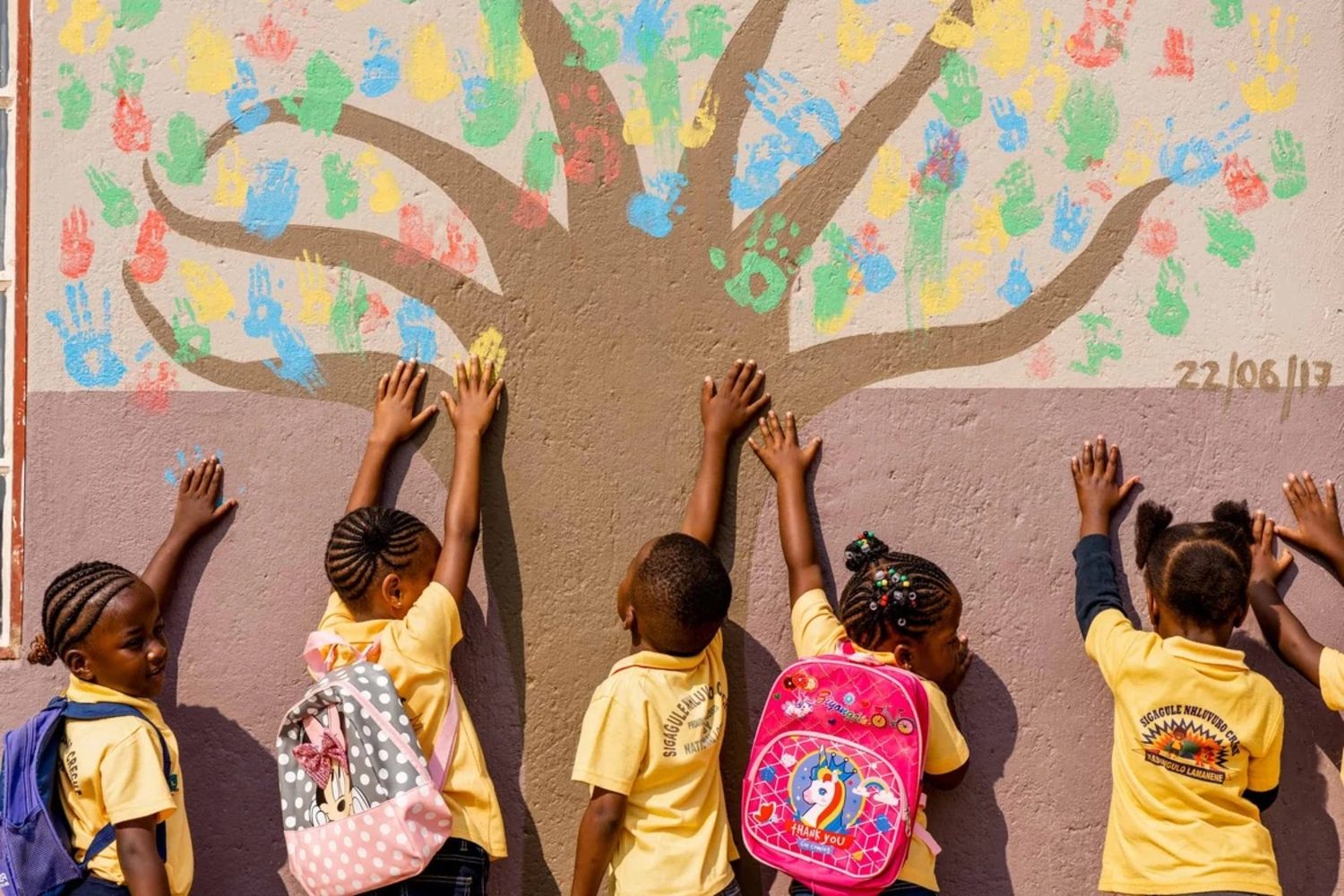 Schoolchildren at a handprint-tree mural