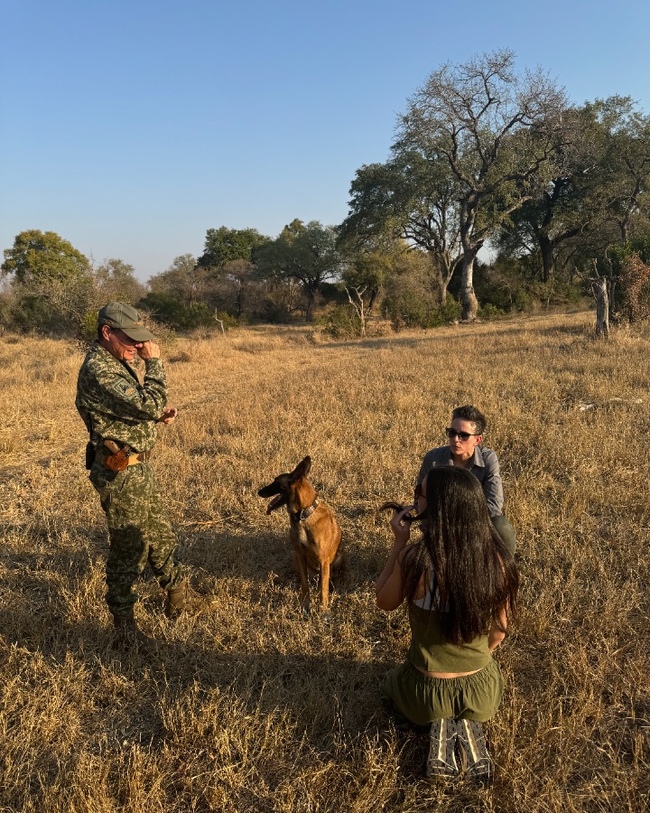 A K9 anti-poaching handler and dog with travelers