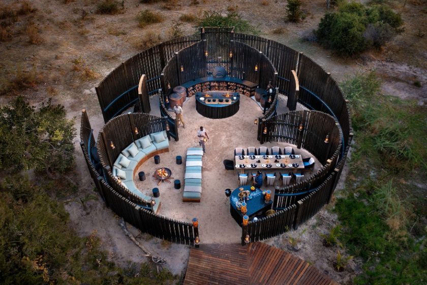 An aerial of a circular bush boma set for dinner
