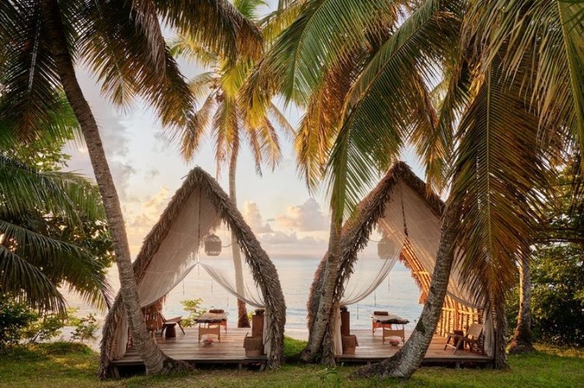 Twin beach cabanas among the palms at sunrise