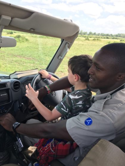 A guide letting a young traveler take the wheel