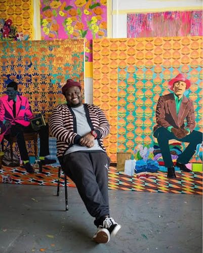 An artist in a studio of vivid hand-painted backdrops